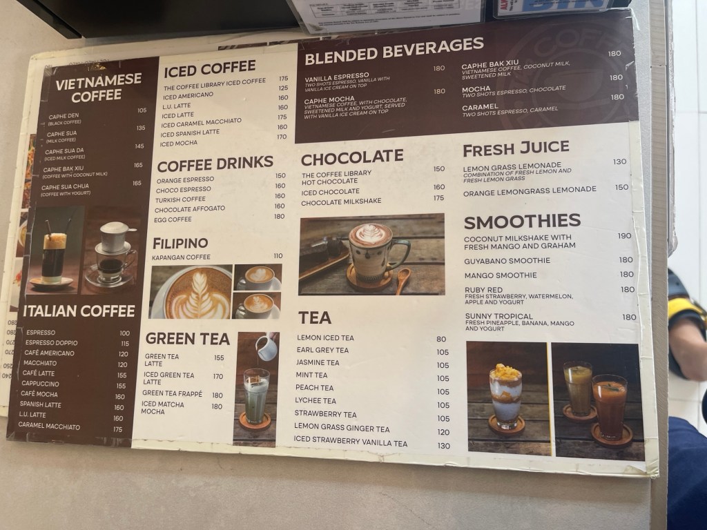 Menu board featuring various coffee and beverage options, including Vietnamese coffee, iced coffee, blended beverages, fresh juices, smoothies, and tea with prices listed.